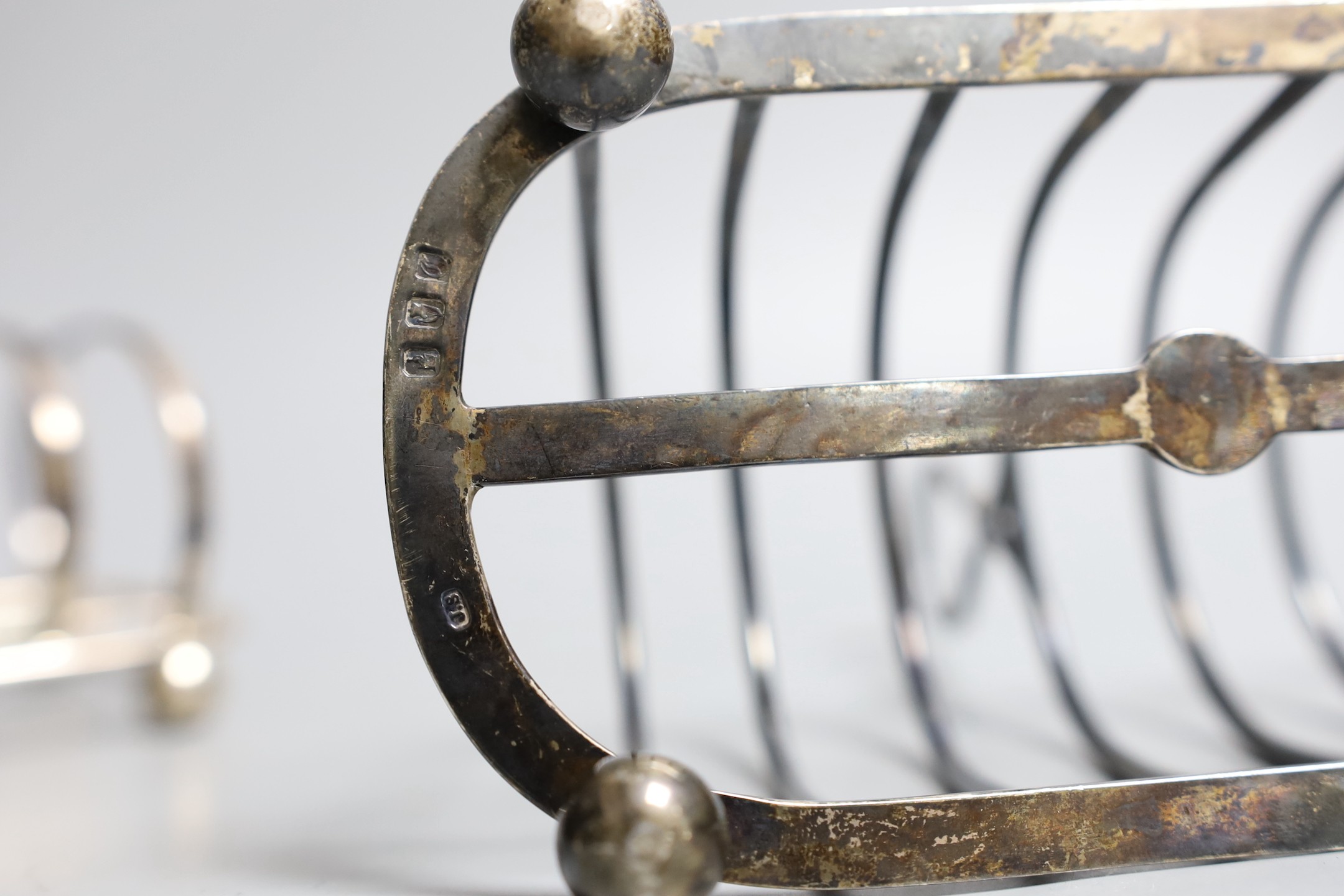 A late Victorian Irish silver seven bar toastrack, John Smyth, Dublin, 1898, length 17.5cm and one other later smaller toastrack by Mappin & Webb, 15.5oz.